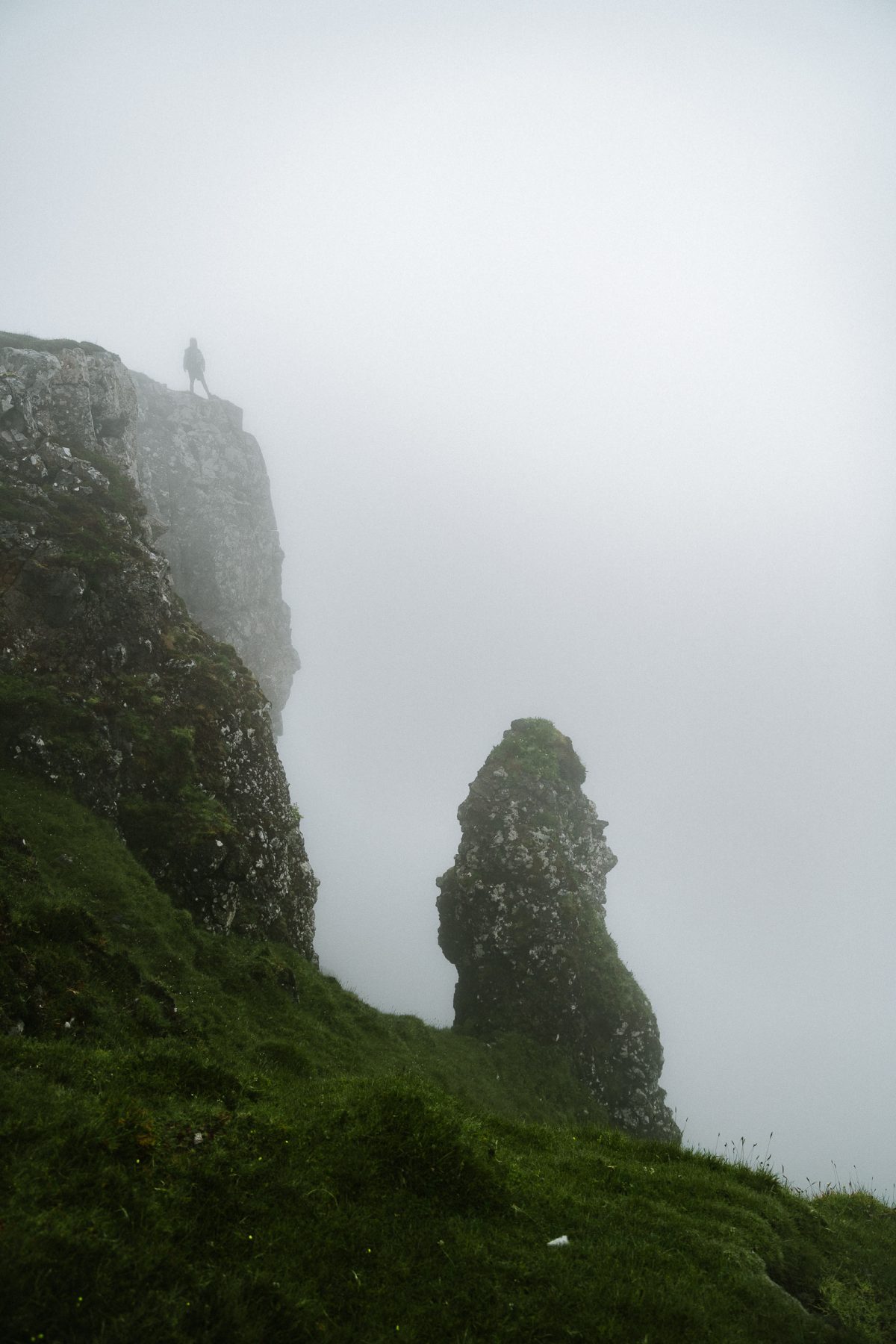 Man staat boven op de klif met afgrond tijdens The Scotland Trail op Skye