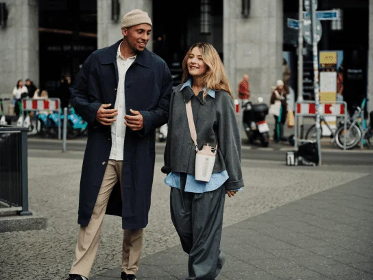 Een man en vrouw wandelend door een stad terwijl de vrouw de Stanley 1913 Cross Bottle in de kleur Rose Quartz omheeft.