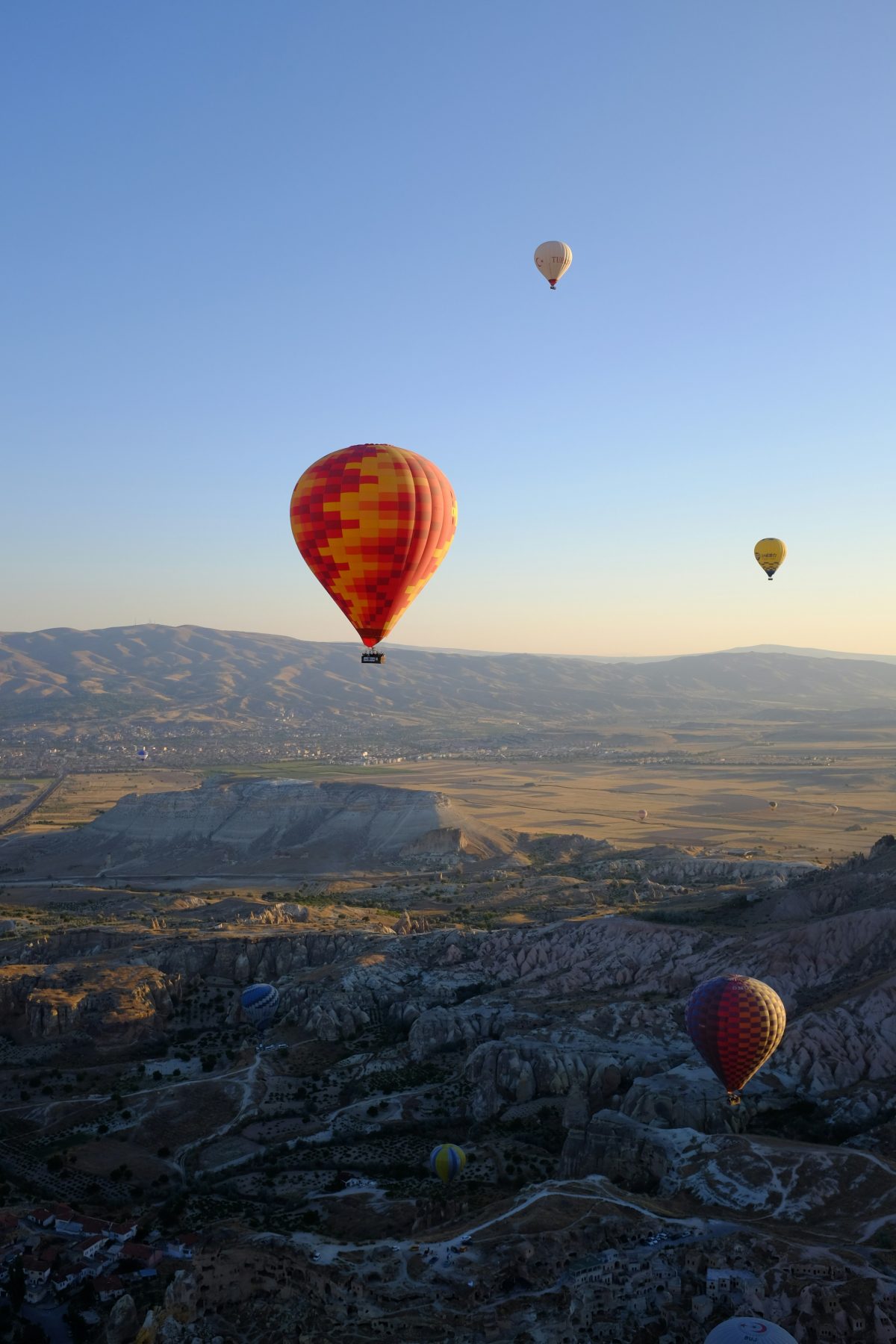 Luchtballonen zwevend boven het landschap van Cappadocië, wat de bestemming van de Cappadocia Trail is.